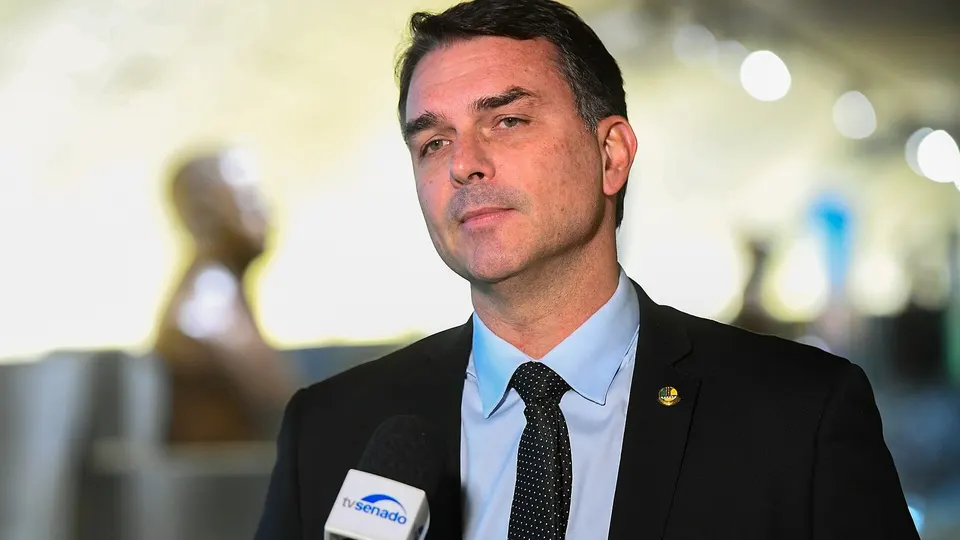 Flávio Bolsonaro de terno, falando em entrevista coletiva no Senado