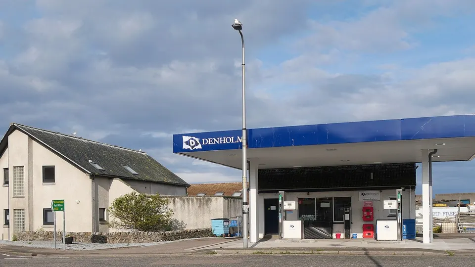 Posto de combustível com bombas de abastecimento e cobertura, visto de frente