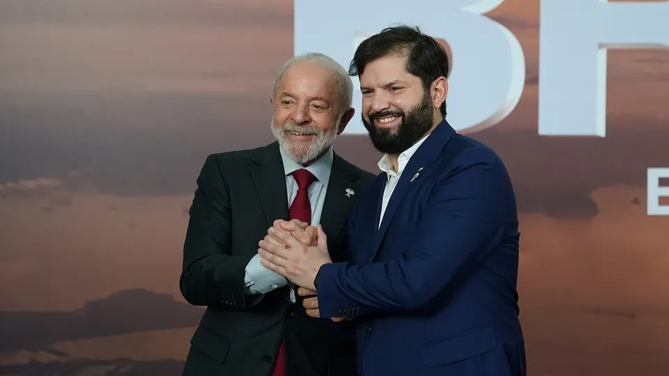 Lula e Gabriel Boric sorrindo lado a lado durante encontro na Cúpula do BRICS em 2025