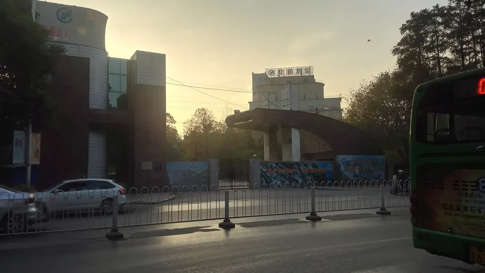 Portão de entrada do antigo sítio da fábrica de cimento Huaxin, na China, com placa em caracteres chineses